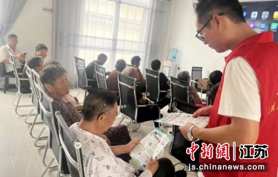 志愿者向老年人发放反诈宣传单。周屯村 供图 志愿者向老年人发放反诈宣传单。周屯村 供图